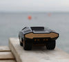 The Playforeer UFO Cannone Car in Black, inspired by 70’s concept cars, captures the spirit of vintage super cars in miniature form on a wood surface.