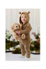 A toddler wearing a tan hooded knit romper with bear ears, cuddling with a Snuggle Bunnies - Honey the Puppy plush toy.