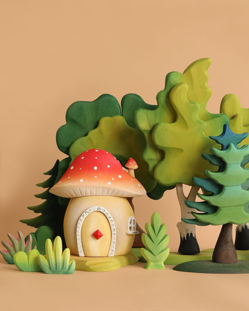 The Handmade Wooden Mushroom House features a red and white spotted roof and sits among green trees and bushes, creating a Montessori and Waldorf-inspired scene on a plain beige background.