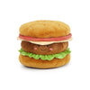 The MON AMI Joe Burger Plush Toy features a smiling face, rosy cheeks, green lettuce, brown patty, yellow bun, and pink felt tomato—all from soft materials—on a white background. This adorable plush is perfect for snuggles.