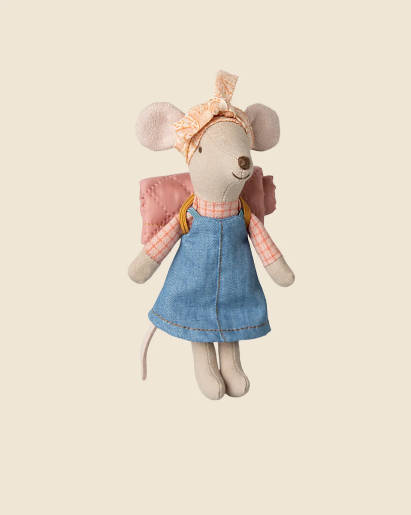 A plush toy mouse in a blue dress and pink plaid shirt, with a pink headband and quilted backpack, stands charmingly against a beige background, ready for adventure with the Maileg Camping Set.