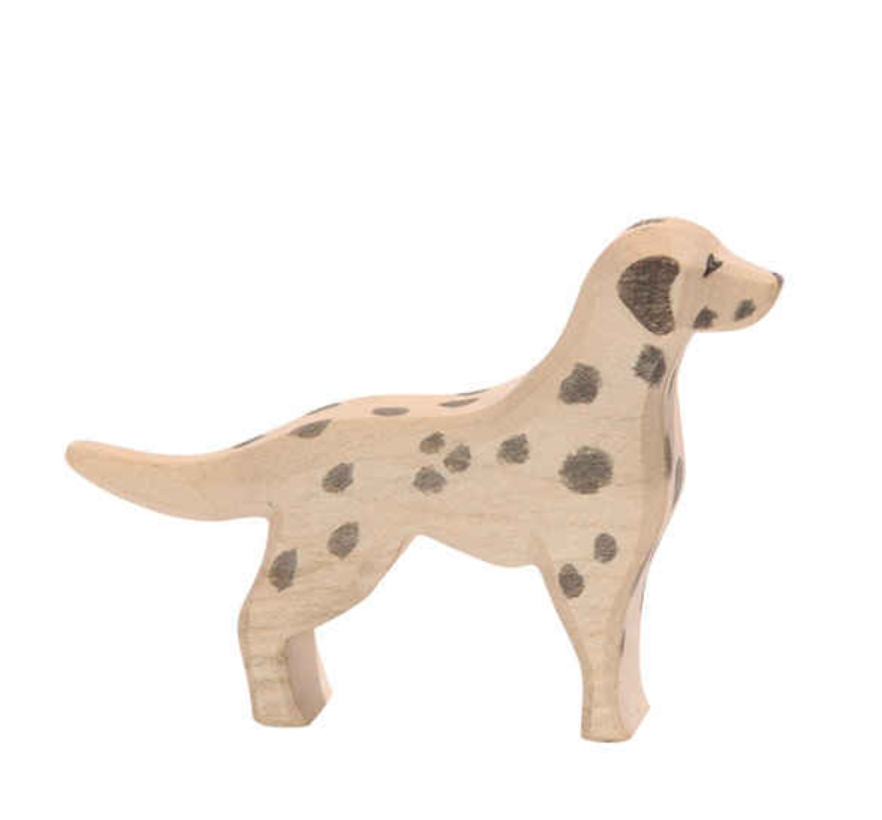 The Ostheimer Dalmatian Dog is a handcrafted wooden toy figurine, painted light beige with black spots, made from sustainably sourced materials, and stands on all four legs against a plain white background.