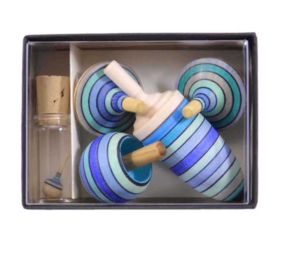 The Mader Spinning Top Champion Learning Set - Ice includes four tops with blue, teal, and black stripes and a glass bottle with a mini striped top—ideal for collectors of all levels.