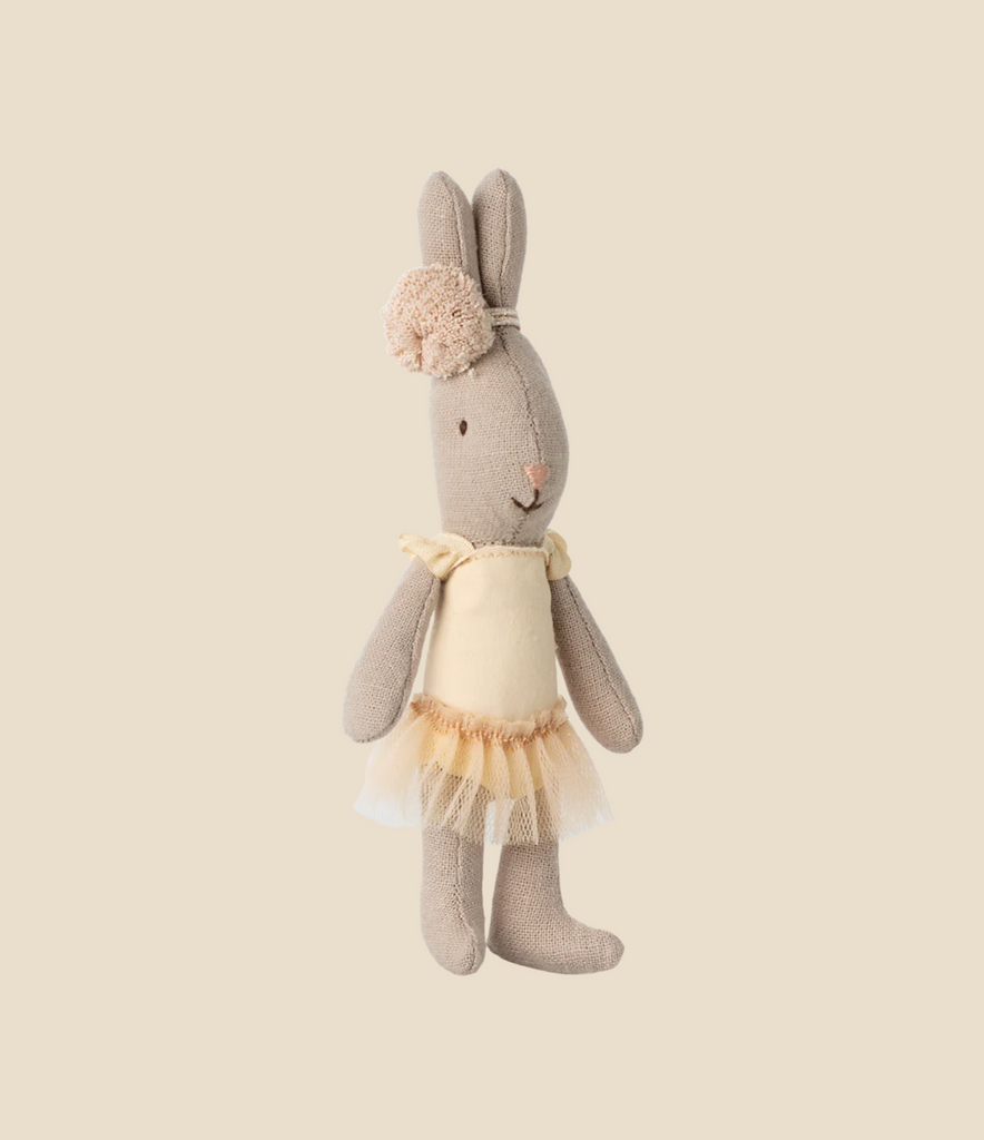 The Maileg Rabbit, Micro - Ballet Suit And Skirt, Cream features a beige plush bunny dressed as a ballerina in a cream dress with tulle skirt and matching flower headband, posed against a plain light beige background.