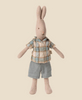 The Maileg Rabbit, Size 1 - Classic, is a linen-cotton stuffed animal standing upright in a blue and white plaid shirt with blue shorts on a light beige background.