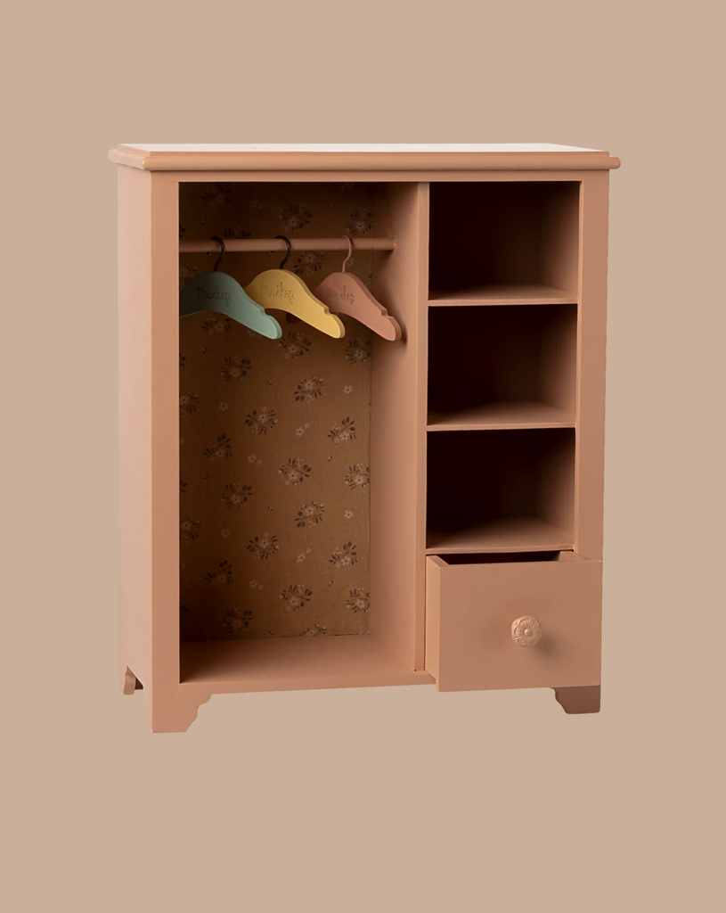 The Maileg Wardrobe, Large - Dark Powder (Large) features four shelves, a bottom drawer, a hanging rod with three colorful hangers, and a floral-patterned back panel—ideal storage for children's rooms.