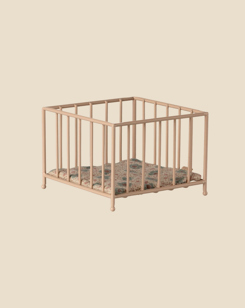 The Maileg Nursery Set features a small, square playpen with pale pink bars and a patterned blanket, shown on a plain beige background.
