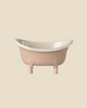 The Maileg Big Sister Bathroom Set features a small, light pink clawfoot bathtub with a cream interior, perfect as a Maileg mouse accessory, displayed against a plain beige background.