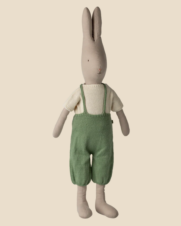 The Pre-order: Maileg Rabbit, Size 5 - Classic, wears a cream shirt and green knitted overall, standing upright against a plain beige background. Expected arrival: 02/15/26.