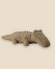 The Pre-order: Maileg Crocodile, Small - Olive Green (expected arrival by 06/15/26) is a soft, plush toy with minimal features and small fabric bumps along its back, shown on a plain light beige background.