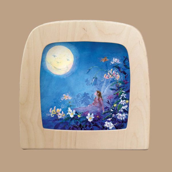 The Silhouette Only - Little Fairy Can't Sleep silhouette - Moon for Toverlux Lamp creates a magical window effect, featuring a woman in a floral garden under a full moon, surrounded by blooms and embraced by the serene blue of the night.