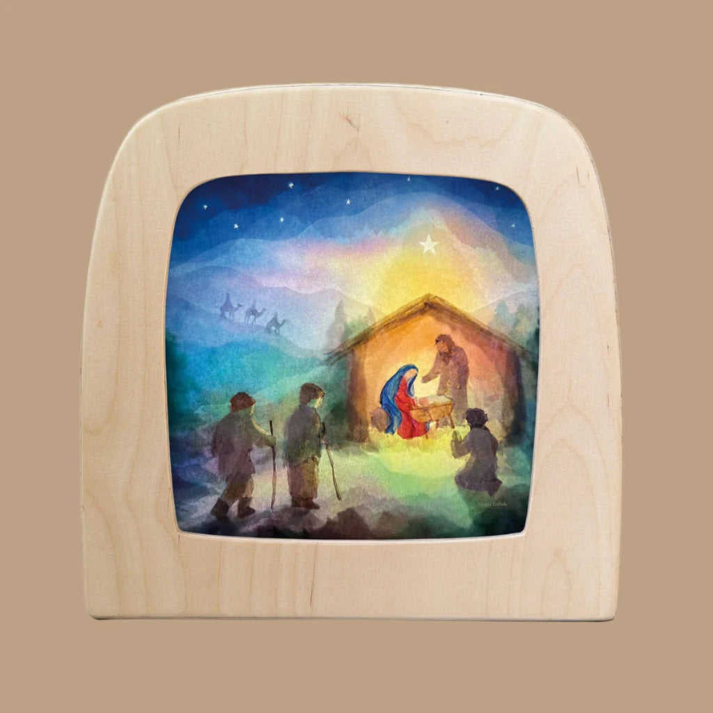 The Silhouette Only - Joseph & Mary for Toverlux Lamp features a nativity scene with Mary, Joseph, and baby Jesus in a glowing manger. With shepherds approaching under a bright star and set against a vivid night sky, the scene appears framed like magic.