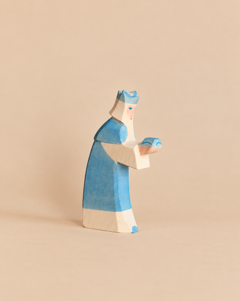 Ostheimer Blue King With Crown, a handcrafted wooden toy of a king in a blue crown and robe holding a small blue gift for imaginative play.