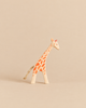 Ostheimer Small Giraffe - Head Low, a handcrafted wooden toy with orange spots and a rope tail, positioned with its head lowered for imaginative play.