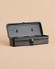 Multi Purpose Steel Storage Box T-320 - Black open toolbox with a front latch on a solid tan background.