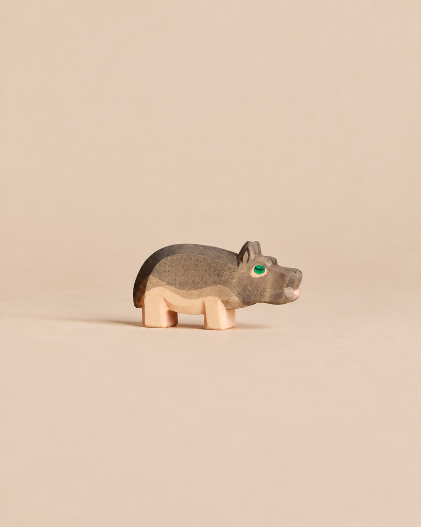 Handcrafted Ostheimer Hippopotamus - Small wooden figurine with a grey back and green eye.