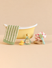Maileg Bathtub Set with a small tub, a green striped towel, a rubber duck, a shampoo bottle, a hairbrush, and a spotted shower cap.