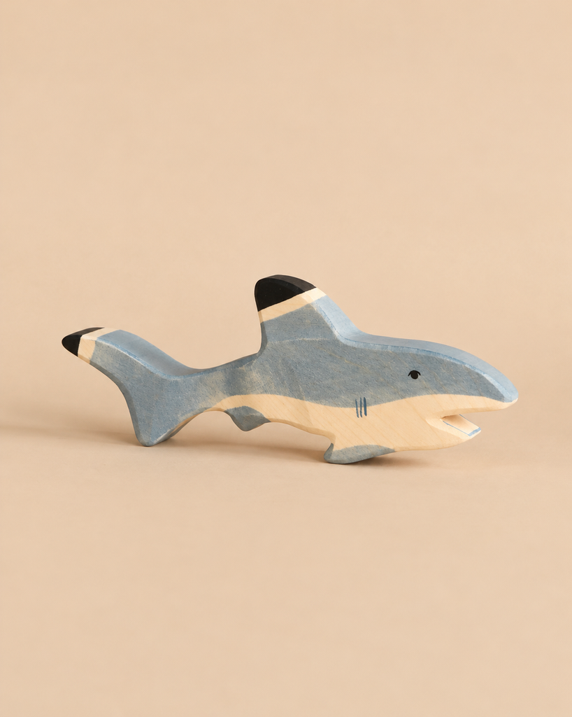 Handcrafted Holztiger Shark wooden toy painted in shades of blue with a black dorsal and tail fin.