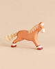 A handcrafted Holztiger Horse, Running, Light Brown figurine in a running pose, featuring painted hooves and a fiber tail.