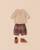 Maileg Pants and Knitted Sweater, Size 4 - Off White, consisting of a beige knitted sweater, brown and orange plaid shorts, and soft brown leather shoes with bows.