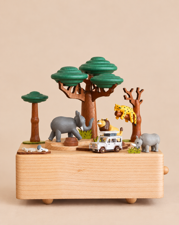 Wooden Safari Music Box featuring a hand-cranked safari scene with a white toy vehicle, a lion, an elephant, a leopard in a tree, and a rhinoceros.