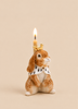 Highness Hare Cake Topper featuring a brown porcelain rabbit figurine with a gold crown, ermine-patterned cape, and a lit birthday candle rising from behind its head.