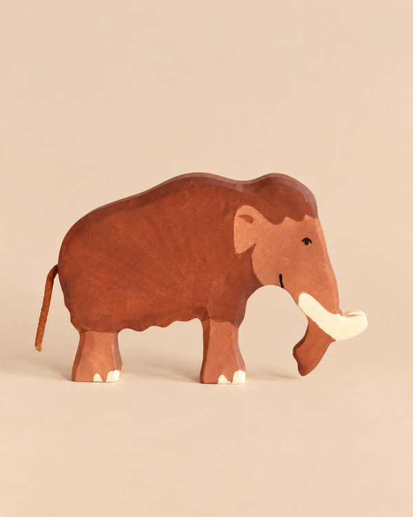 Handcrafted wooden Holztiger Mammoth toy in shades of brown with a small tail and curved tusks.