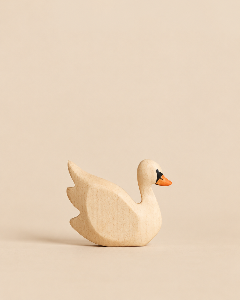 A handmade wooden toy swan figurine with an orange beak from the Handmade Holzwald Fishing Pond Set.
