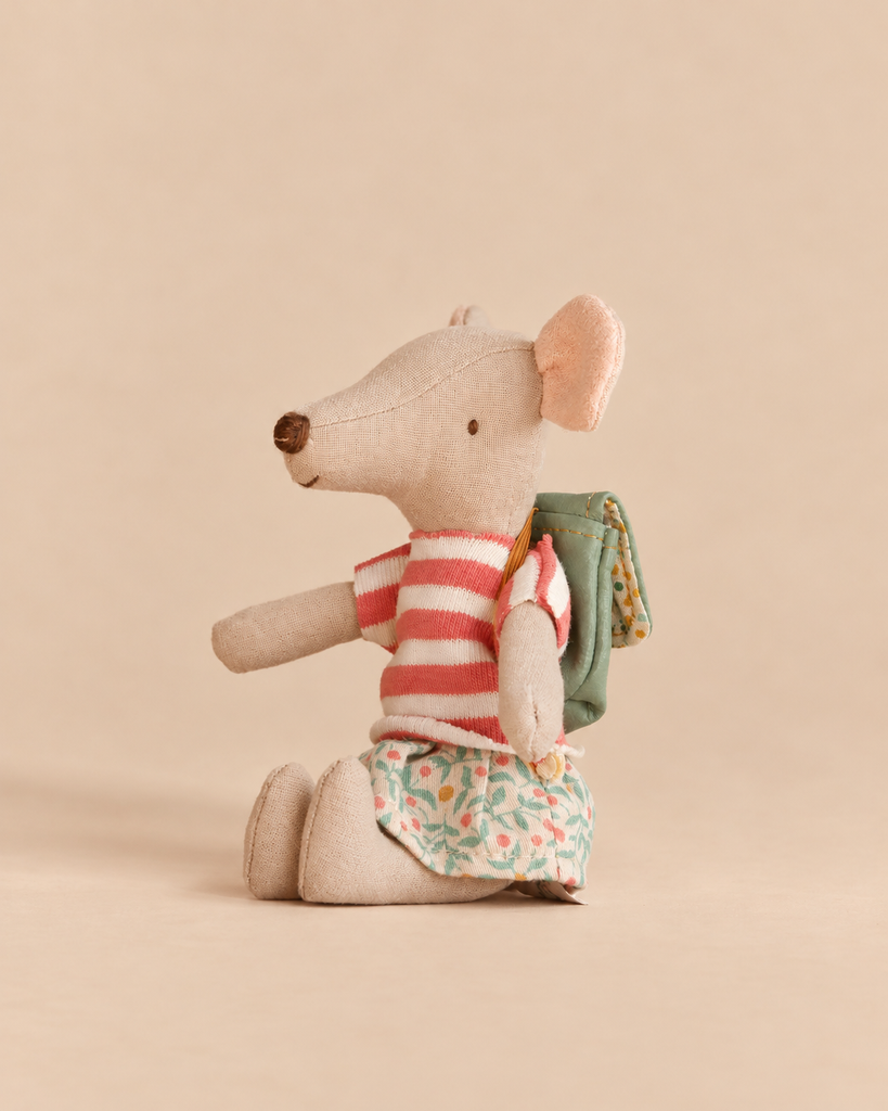 Stuffed mouse toy wearing a striped shirt, a floral skirt, and a green backpack, shown here with a Maileg Bathtub Set and a tricycle.