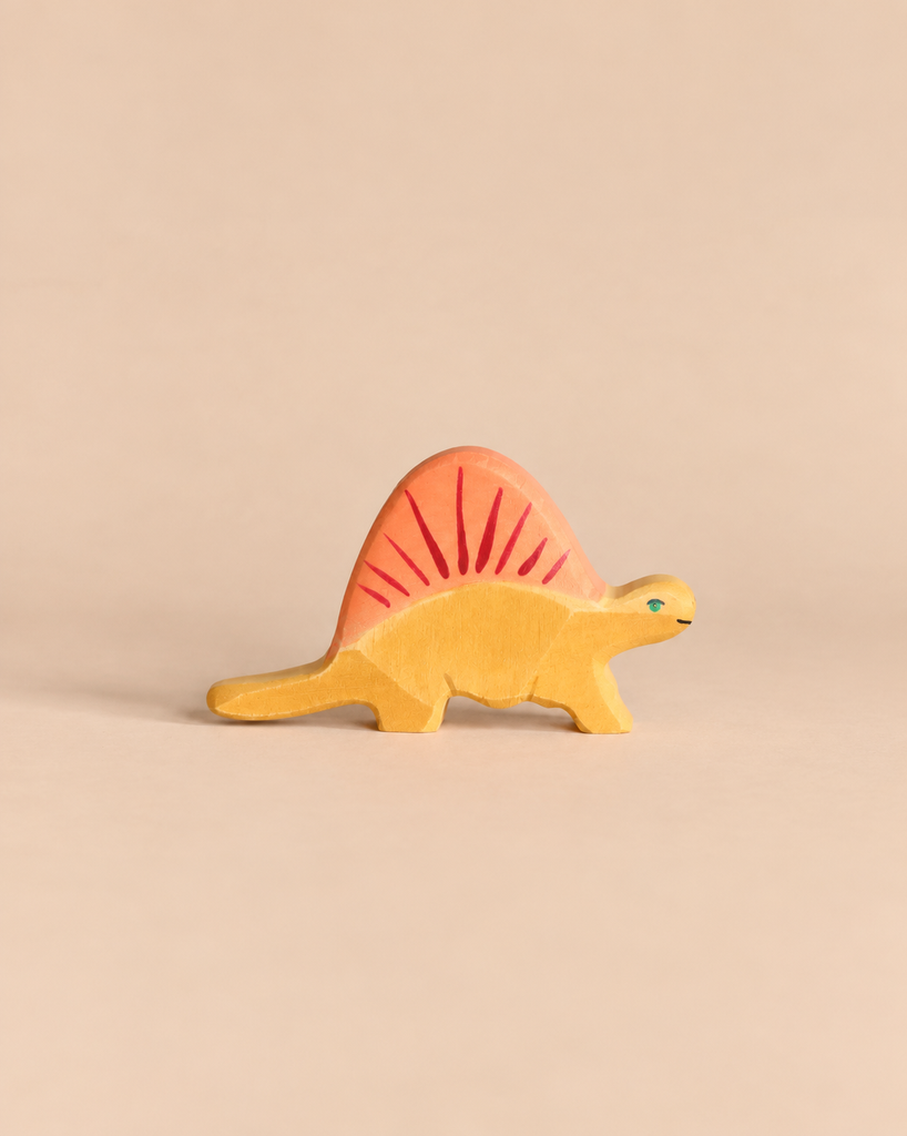 A handcrafted Holztiger Dimetrodon Dinosaur toy with a yellow body and a reddish-orange sail.