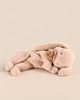A Maileg Plush Sleeping Bunny - Powder lying down with a fabric flower detail at its neck.