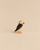 Handmade Holzwald Bird - Puffin, a small, sustainable wooden figurine with black, white, and red coloring standing on an orange base.