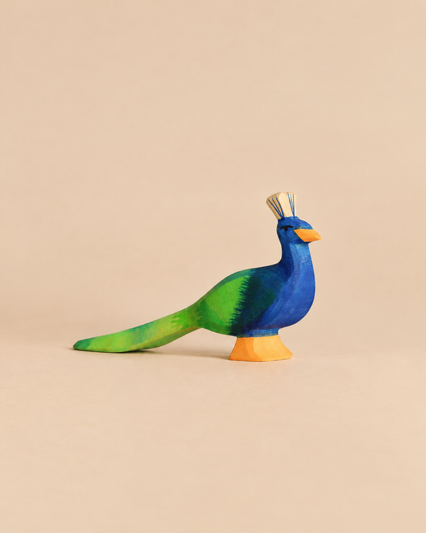 Ostheimer Peacock, a handcrafted wooden figurine painted in shades of blue and green with an orange base.