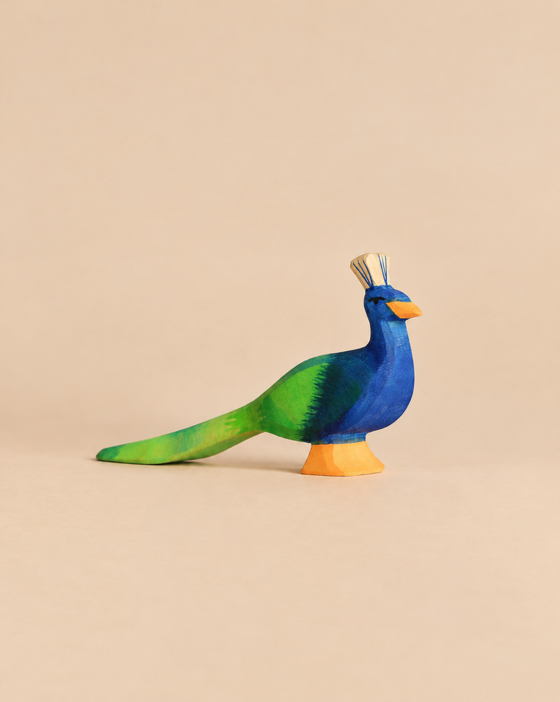 Ostheimer Peacock, a handcrafted wooden figurine painted in shades of blue and green with an orange base.