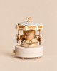 Wooden Carousel Music Box with miniature horses, featuring a cream-colored base and canopy with gold-tone decorative details.
