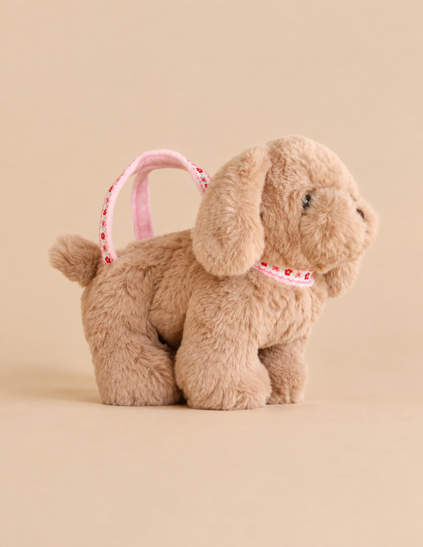 Fluffy tan Konges Sloejd Puppy Bag with a pink floral print handle and collar.