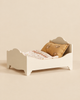 Maileg Wooden Bed, Mouse - Off White with a floral pillow and a quilted blanket.