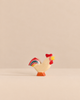 Handmade Holzwald Bremer Rooster figurine with a red comb, yellow beak, and a colorful striped tail.