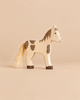 Holztiger Horse Foal, Standing: a handcrafted wooden toy horse with brown spots, a painted face, and a fibrous tail.