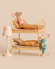 Two Maileg mice in pajamas resting in a Maileg Bunk Bed Bedroom Set with Little Brother & Sister beside a vintage floor lamp.