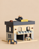 Konges Sloejd Wooden Police Station with a helicopter on the roof and two wooden toy cars in front.