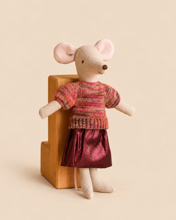 A Maileg Mom Mouse With Extra Outfit - Petite Couture doll wearing a striped sweater and a dark red skirt, standing against a small wooden block.