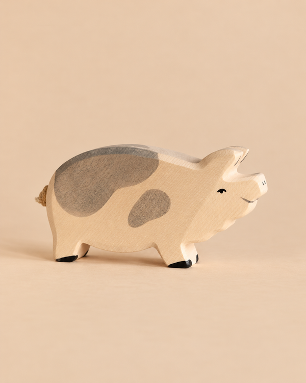 Holtztiger Boar, a small handcrafted wood toy pig with gray patches on its back and side.