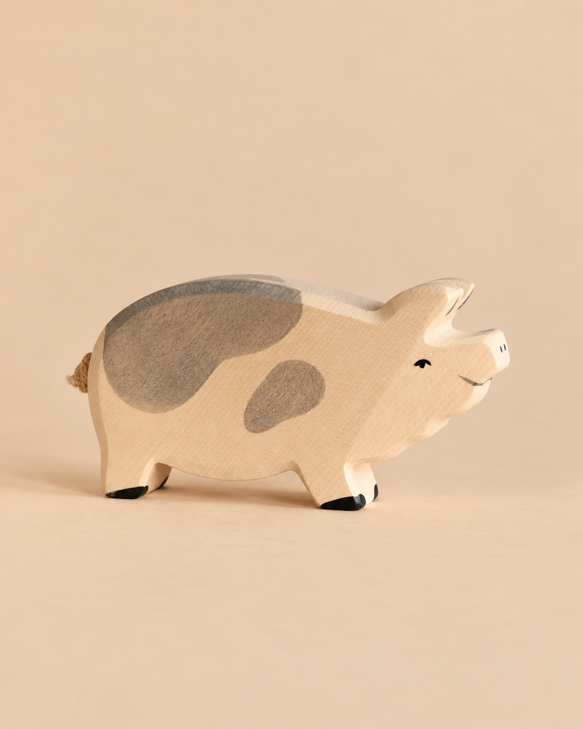 Holtztiger Boar, a small handcrafted wood toy pig with gray patches on its back and side.
