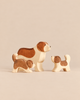 An Ostheimer Handmade Wooden Dog Family Set consisting of one large dog and two smaller puppies, all handcrafted with painted brown markings.