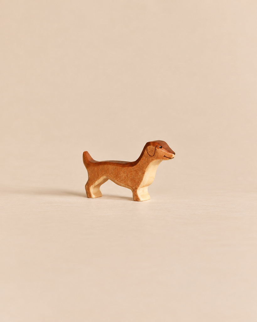 Small, handmade wooden dog figurine from the Handmade Holzwald Shepherd & Farm Animals Set, painted in shades of brown.