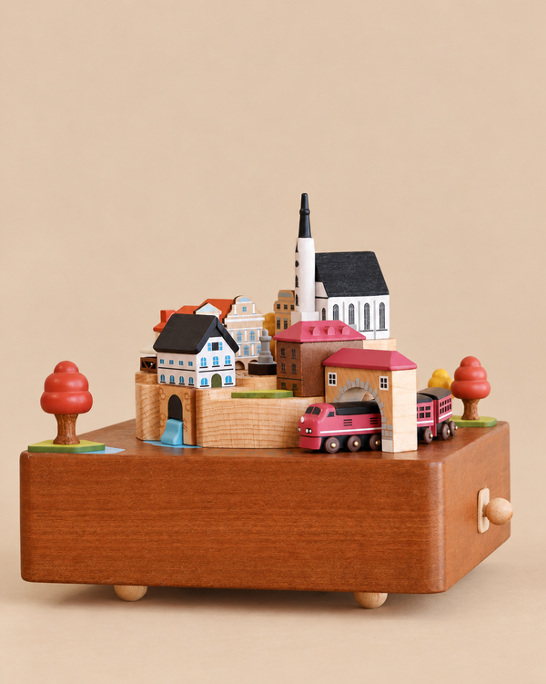 Wooden Train Music Box - European Town featuring a miniature European town scene with a red train and a church tower on top.
