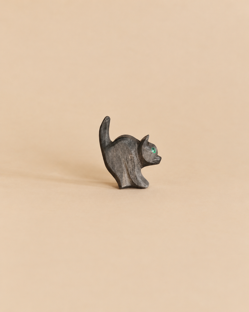 Small black Ostheimer Cat For Witch wooden figurine with a raised tail and a single green eye.