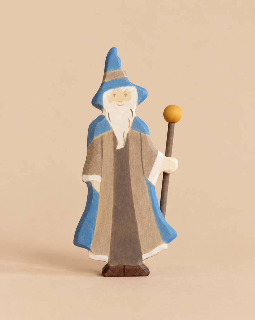 Holztiger Magician handcrafted wooden figure of a bearded wizard in a blue hat and robe, holding a staff with a yellow orb at the top.