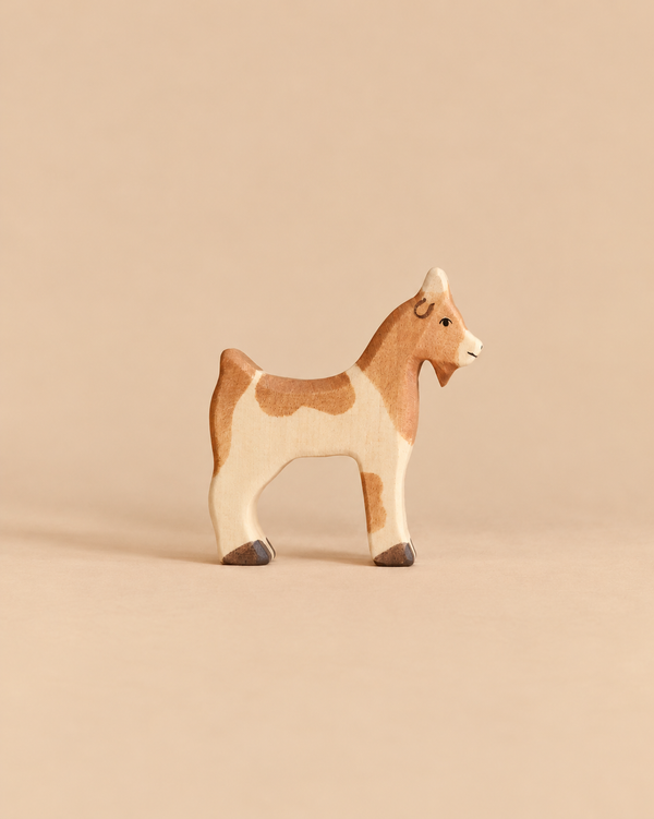 Handcrafted wooden Holztiger Goat toy figure with white and brown patches.